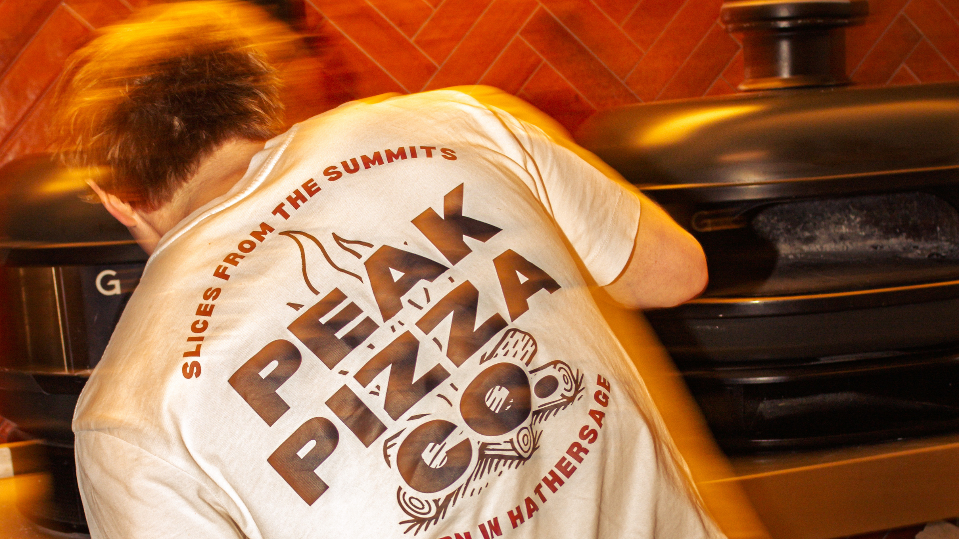 Peak Pizza Co. pizza chef in pizza kitchen with wood-fired pizza oven