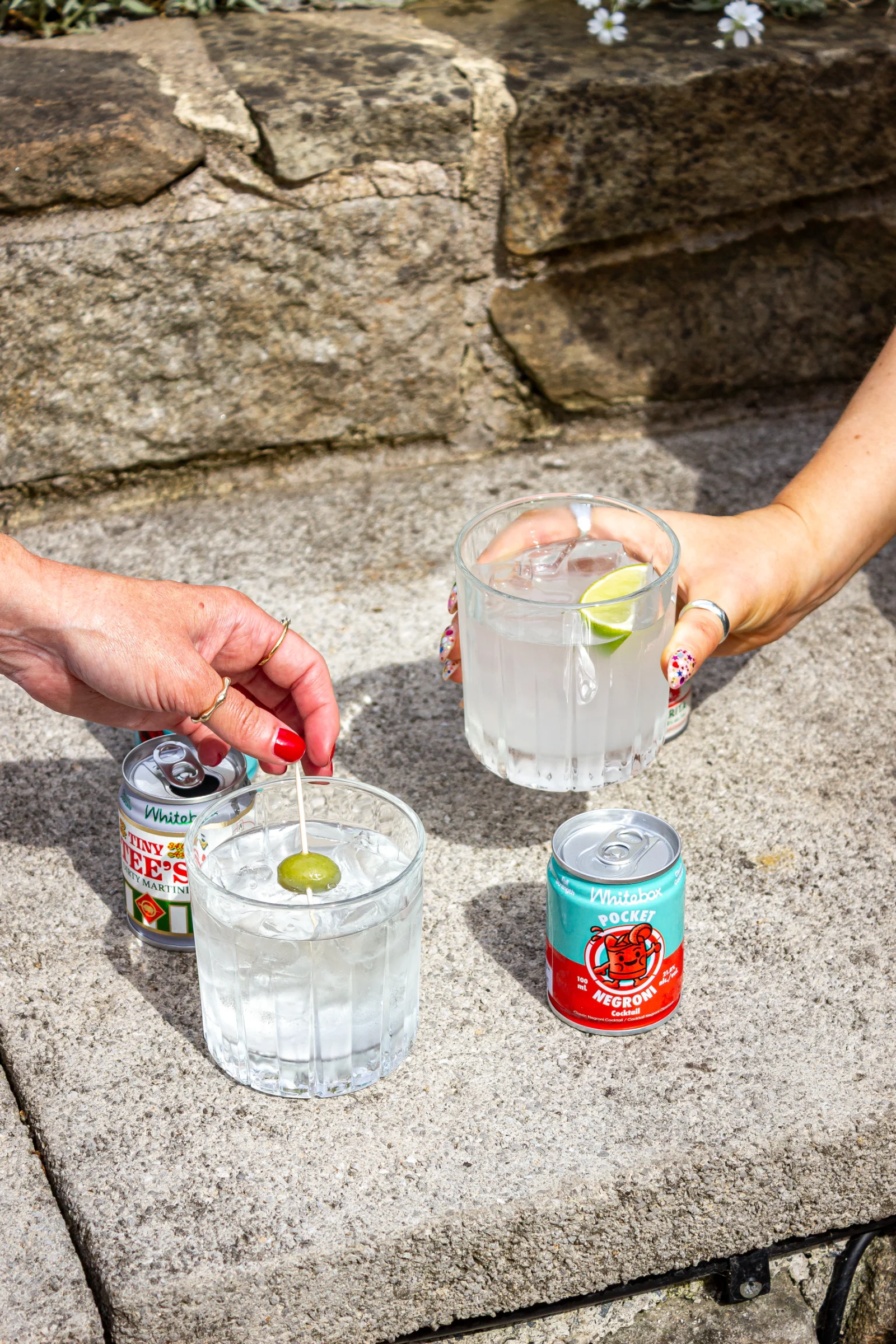 Guests drinking specialty cocktails, dirty martini and negroni cans