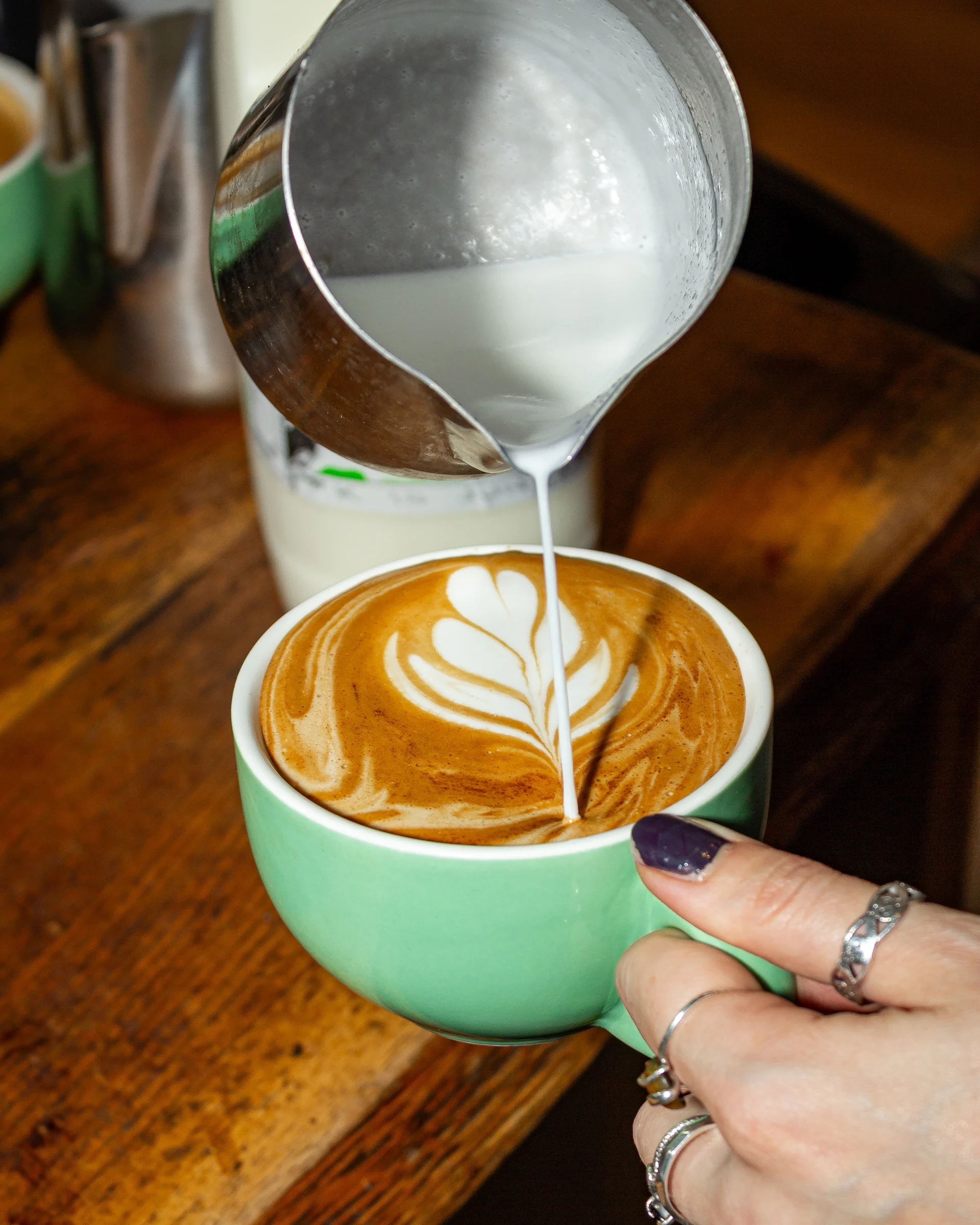 A perfect Freshly made espresso and latte being poured at Castleton Kitchen